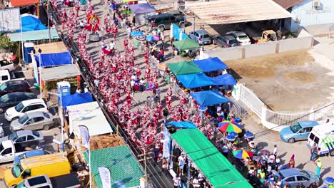 High-angle-static-aerial-of-red-costumed-grand-march-performers-in-Curacao-for-Carnaval-fun