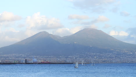 View-of-Mount-Vesuvius-and-city-of-Naples,-sailboats-sailing-in-foreground