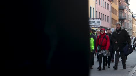 People-march-with-signs-in-anti-Covid-regulation-protest,-static-shot