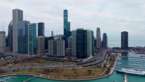 Drone-Dando-Vueltas-Por-La-Orilla-Del-Lago-Y-El-Nuevo-Lado-Este,-Oscuro,-Día-De-Primavera-En-Chicago