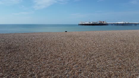 Dramatic-flyover-Brighton-beach,-UK-with-beachgoers