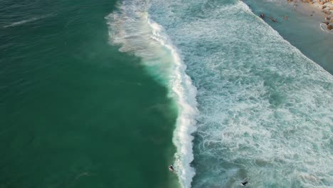 Surfers-Ride-On-Crashing-Waves-Of-Llandudno-Beach-In-Cape-Town,-South-Africa
