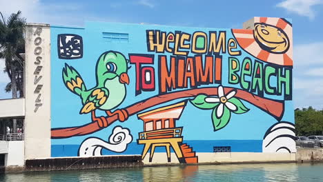 Willkommen-In-Miami-Beach,-Graffiti-Wandbild-Auf-Dem-Gebäude-An-Einem-Sonnigen-Tag-Aus-Nächster-Nähe