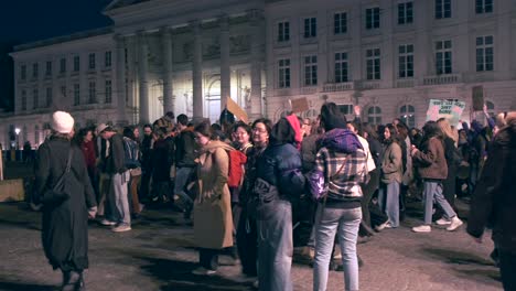 Crowd-gathered-for-women's-rights-rally-in-urban-evening-settin