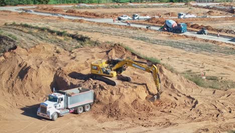 Yarrawonga,-Victoria,-Australia---8-March-2024:-Excavator-loading-a-tip-truck-with-dirt-from-a-stockpile-at-Silverwoods-Estate-in-Yarrawonga