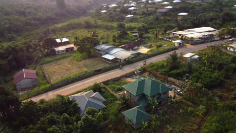 Motorbike-traffic-in-the-suburbs-of-Ebolowa,-golden-hour-in-Cameroon---Aerial-view