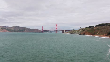 Niedrige-Schwenks-Nach-Links-Drohnenaufnahme-Der-Golden-Gate-Bridge-An-Einem-Bewölkten-Tag