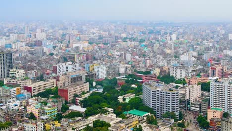 Rising-drone-shot-of-Dhaka,-Bangladesh-with-colourful-buildings-and-green-space