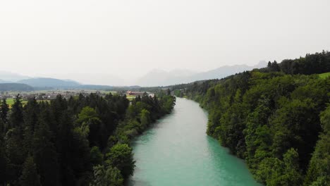 Aerial-of-a-river-surrounded-by-forest-and-hills