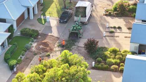 Yarrawonga,-Victoria,-Australia---6-March-2024:-Tree-worker-pushing-small-branches-into-a-chipper-machine-in-a-suburban-street