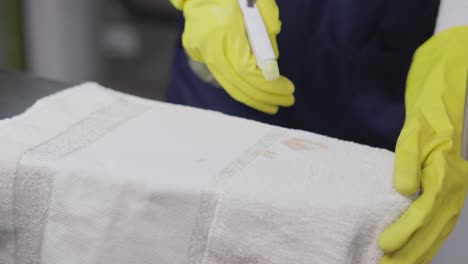 Worker-In-A-Dry-Cleaning-Workshop-Spraying-Stain-On-Cotton-Towel