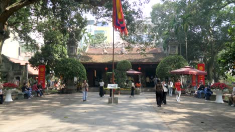 Bustling-Quan-Thanh-Temple-in-Hanoi,-visitors-enjoying-the-serene-atmosphere,-daylight-shot