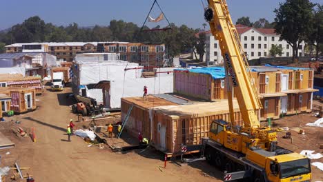 Aerial-rising-close-up-shot-of-a-heavy-duty-lift-crane-at-a-housing-development-site-in-West-Los-Angeles,-California