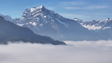 Alpine-peaks-piercing-through-a-sea-of-clouds,-Swiss-Alps