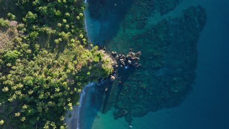 Sunset-aerial-view-over-Caribbean-coastline-with-beaches,-palm-trees-and-reef