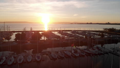 Langsamer-Drohnenflug-über-Einen-Bootssteg-Bei-Sonnenaufgang-Auf-Der-Kalifornischen-Halbinsel,-Seevögel,-Segelschiffe,-Luftaufnahmen-Hiermit