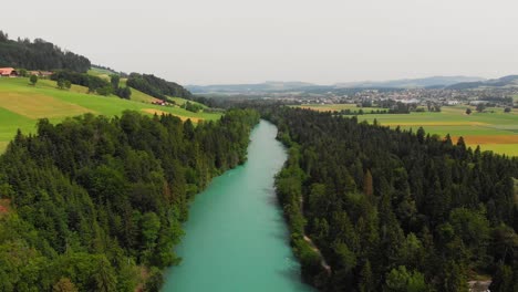 Aerial-of-a-river-surrounded-by-forest-and-hills