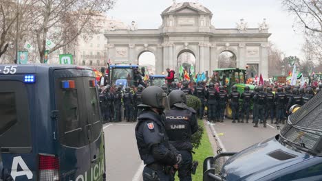 Polizisten-Stehen-Wache,-Als-Sich-Spanische-Landwirte-Und-Agrargewerkschaften-Auf-Der-Plaza-De-La-Independencia-Versammeln,-Um-Gegen-Unlauteren-Wettbewerb,-Agrar--Und-Regierungspolitik-Zu-Protestieren