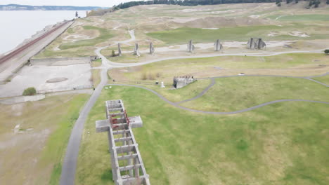 Toma-Aérea-De-Un-Parque-Con-Estructuras-De-Hormigón,-Agua-Nueva-Y-Vías-De-Tren-En-Chambers-Bay.