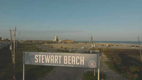 Una-Antena-De-Tarde-Alejando-La-Vista-De-La-Señal-De-Entrada-De-Stewart-Beach-Y-Stewart-Beach-En-La-Isla-De-Galveston,-Texas