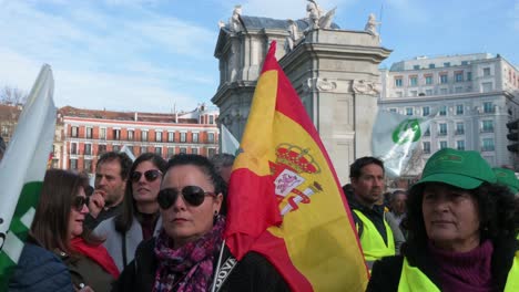 Eine-Spanische-Demonstrantin-Hält-Eine-Spanische-Flagge,-Während-Sich-Landwirte-Und-Demonstranten-Der-Agrargewerkschaft-An-Der-Puerta-De-Alcalá-In-Madrid-Versammelten,-Um-Gegen-Unlauteren-Wettbewerb-Und-Agrarpolitik-Zu-Protestieren