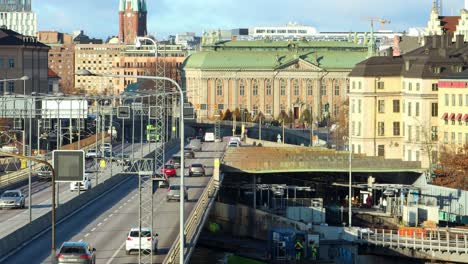 Tráfico-De-Automóviles-En-Puentes-Y-Edificios-A-La-Luz-Del-Sol-Por-La-Noche-En-Estocolmo
