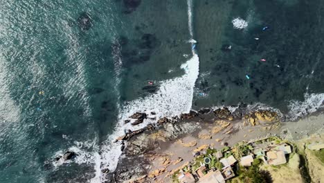 Olas-y-mar-visto-desde-arriba-con-surfistas-en-Punta-de-Lobos-Chile