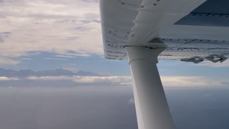 4K-footage-of-wing-in-a-Gippsland-GA8-Airvan-with-view-of-mountains-and-ocean-in-background