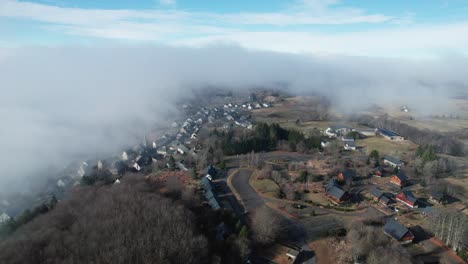 Aerial-view-of-a-village-in-France,-covered-in-fog