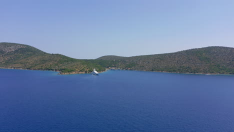 Aerial:-A-yacht-is-anchored-on-the-coast-of-Peristera-Greek-island-in-Sporades-during-a-summer-clear-day