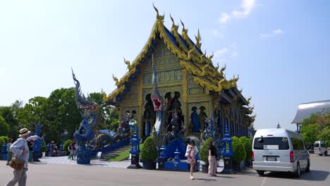 Tourists-enjoying-views-at-famous-blue-temple-in-Chiang-Rai,-Thailand