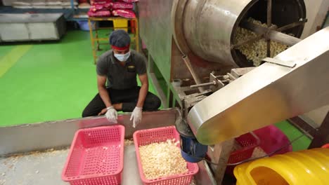 POV-Shot:-Das-Popcorn-Kommt-Fertig-Aus-Der-Maschine-Und-Männer-Bringen-Das-Popcorn-Zum-Verpackungsband