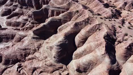 Aerial-looks-down-onto-smooth-eroded-slopes,-canyons-in-badland-clay