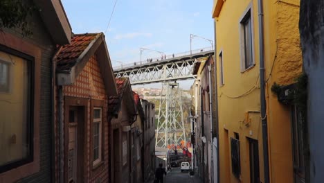 Descending-shot-of-narrow-street-in-Gaia-by-Dom-Luis-I-Bridge-in-Porto,-Portugal