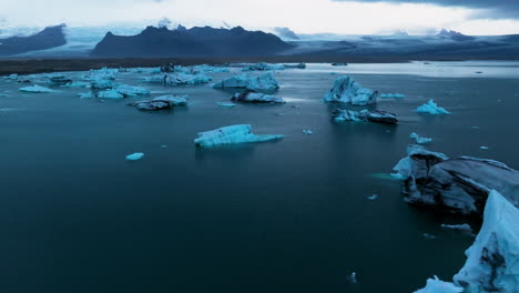 Floating-Icebergs-In-Jökulsárlón-Glacier-Lagoon-At-Sunrise-In-Iceland---Aerial-Drone-Shot