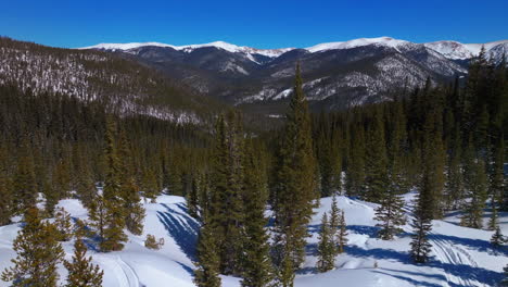 Snowmobile-trail-track-Boreas-Mountain-Pass-Breckenridge-Colorado-aerial-drone-cinematic-Backcountry-blue-clear-sky-North-Fork-Tiger-Road-Bald-Rocky-Mountains-Keystone-winter-fresh-snow-forward-pan-up