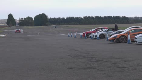 Static-shot-of-multiple-supercars-heading-out-onto-a-racetrack-to-race