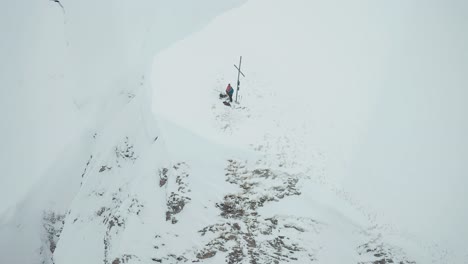 Alpinskifahrer-Stehen-Auf-Dem-Schneebedeckten-Berggipfel-In-Der-Nähe-Des-Kreuzes