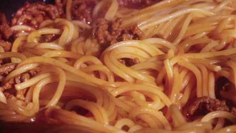 Slow-close-up-panning-shot-of-spaghetti-mixed-with-meat-and-tomato-sauce