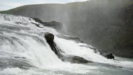 Magnífica-Toma-Panorámica-Estática-De-Una-Majestuosa-Cascada-Que-Se-Precipita-Sobre-Rocas-De-Río-Formando-Rápidos-De-Aguas-Blancas