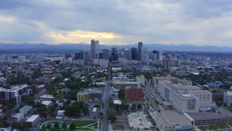 Parque-De-La-Ciudad-Denver-Colorado-Antena-Drone-Thomas-Jefferson-Escuela-Secundaria-Nublado-Gris-Tarde-Atardecer-Primavera-Verano-Centro-De-La-Ciudad-Horizonte-Escénico-Paisaje-Barrio-Montañas-Rocosas-Movimiento-Hacia-Adelante