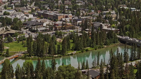 Banff,-AB,-Kanada,-Luftaufnahme-V39,-Gezoomter-Drohnenüberflug-Vom-Stadtzentrum-Weg,-Der-Die-Malerische-Stadtlandschaft-Am-Unberührten-Bow-River-Einfängt,-Umgeben-Von-Bergketten-–-Aufgenommen-Mit-Mavic-3-Pro-Cine-–-Juli-2023