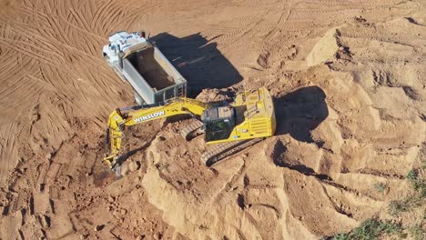 Yarrawonga,-Victoria,-Australia---8-March-2024:-Excavator-filling-a-tip-truck-at-a-construction-site-in-Silverwoods-Estate-in-Yarrawonga