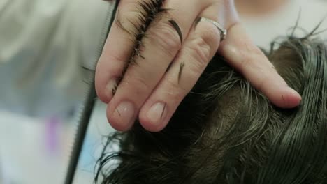 Closeup-of-a-hairdresser's-hands-cutting-a-man's-hair