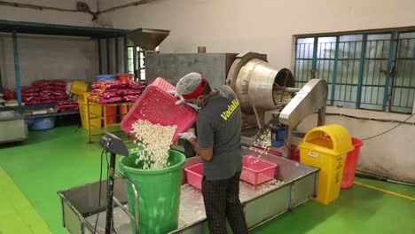 pov-shot-wide-angle-Seen-Man-pouring-popcorn-into-a-big-bucket-and-filling-different-buckets