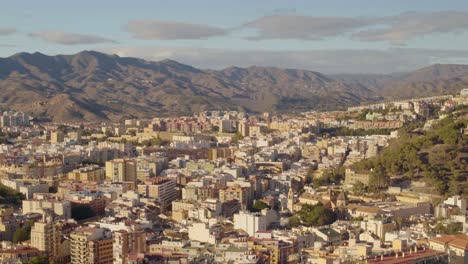 Vista-Alta-De-La-Ciudad-Con-Un-Hermoso-Paisaje-De-Colinas-Con-Luz-Solar,-Málaga,-España.