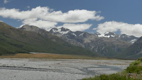 Slow-motion-pan-across-snow-capped-mountains-with-a-river-in-the-foreground---New-Zealand
