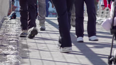 Beine-Und-Füße-In-Winterkleidung-Gehen-An-Einem-Sonnigen,-Aber-Kalten-Wintertag-über-Eine-Fußgängerbrücke