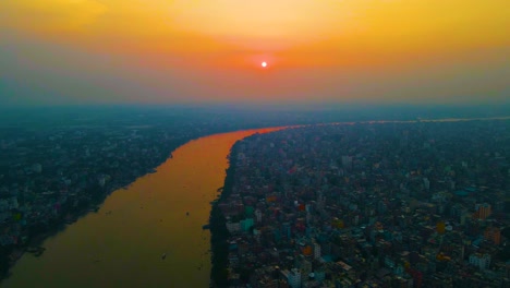 Luftaufnahme-über-Die-überfüllte-Stadtlandschaft-Am-Flussufer-Von-Dhaka-Am-Buriganga-Fluss-Unter-Farbenfroher,-Verschmutzter-Atmosphäre-In-Bangladesch