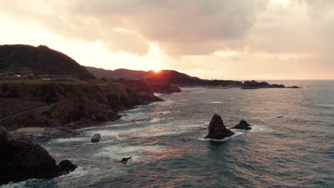 Luftfeuer,-Goldenes-Skyline-Sonnenuntergangspanorama-Am-Japanischen-Strand,-Meereswellen-Brechen-Die-Uferfelsenformation-Von-Kyotango,-Kyoto-Reiseziel-In-Japan,-Asiatischer-Sommer-Drohnenschuss